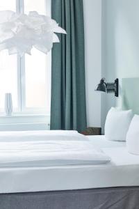 a white bed in a room with a window at Hotel Trabener Hof in Traben-Trarbach