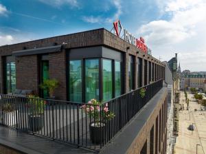 a building with potted plants on a balcony at Hotel Diament Plaza Katowice in Katowice