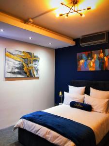 sypialnia z dużym łóżkiem z niebieskimi ścianami w obiekcie Queen Julie Lodge w Kapsztadzie