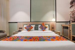 FabHotel Heaven In في نيودلهي: غرفة نوم مع سرير كبير ولحاف ملون