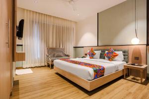 una habitación de hotel con una cama grande y una silla en FabHotel Heaven In, en Nueva Delhi