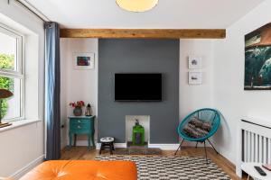 a living room with a flat screen tv on a wall at Ocean Cottage - Walk to Beach Countryside Views in Saundersfoot