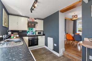 a kitchen with a sink and a stove top oven at Ocean Cottage - Walk to Beach Countryside Views in Saundersfoot