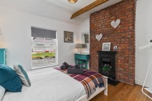 a bedroom with a bed and a brick wall at Ocean Cottage - Walk to Beach Countryside Views in Saundersfoot