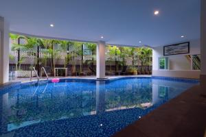 a large swimming pool in a hotel with a blue ceiling at The Hideaway Resort Pattaya by Rosewood in Pattaya South