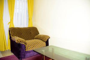sala de estar con silla y mesa de cristal en Beautiful 1BR with Wi-Fi & secure parking, en Kakamega