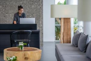 a woman standing at a desk with a laptop at The Splash Koh Chang in Ko Chang