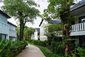 a path between two buildings with trees and plants at The Splash Koh Chang in Ko Chang