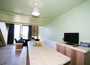 sala de estar con mesa de madera y TV de pantalla plana en Tarset Tor - Bothy 2, en Hexham