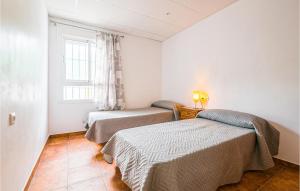two beds in a small room with a window at Stunning Home In Arcos De La Frontera in Arcos de la Frontera