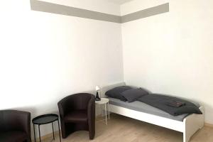 um quarto com uma cama, 2 cadeiras e uma mesa em Cozy Apartments in Zwickau em Zwickau