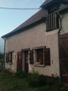 una casa antigua con persianas marrones y una ventana en Chambre Cosy, Nature, wifi et salle de bain en La Roche-Posay