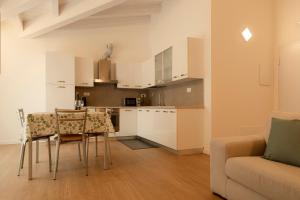 a kitchen and living room with a table and a couch at HOLIDAY APARTMENTS GIULIA - Green in Pietramurata