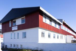un bâtiment rouge et blanc avec un toit noir dans l'établissement Nordbo in Centrum, à Nuuk