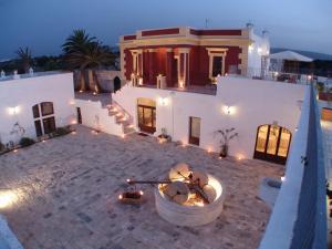 une grande maison blanche avec un foyer extérieur en face de celle-ci dans l'établissement Hotel Masseria Fortificata Donnaloia, à Monopoli