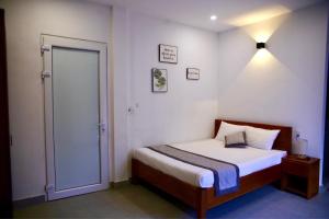 um pequeno quarto com uma cama e uma porta em The Sun Homestay em Hue