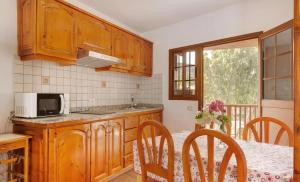 a kitchen with wooden cabinets and a table with a microwave at Holiday Cottage Santa Lucía 1 in Santa Lucía