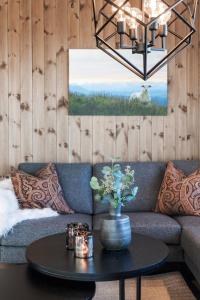 a living room with a couch and a table at Golsfjellet - Bualie, milevis med sykkelveier, fiske og vannaktivitet, ski inn/ut til alpinanlegg og langrennsløyper. in Gol