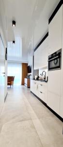 a kitchen with white cabinets and a stove top oven at Apartamenty Aquarius Gold Boszkowo in Boszkowo