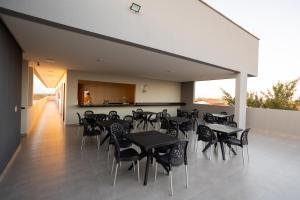 a restaurant with black tables and chairs on a floor at Euro Flat Hotel in Parnaíba