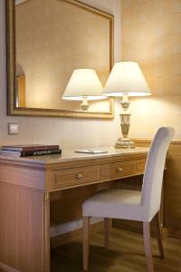 a desk with a lamp and a chair and a mirror at Divani Palace Acropolis in Athens