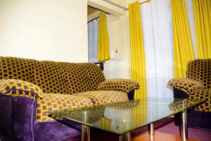 Kakamega的住宿－Beautiful 1BR with Wi-Fi & secure parking，带沙发和玻璃桌的客厅