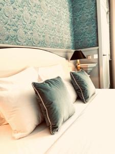 a white bed with pillows and a blue wall at Château de Fontager in Serves-sur-Rhône