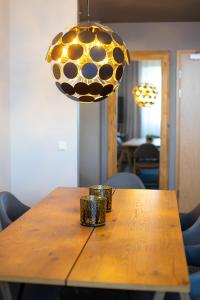 a wooden table with chairs and a pendant light at Centrum Hotel Viljandi in Viljandi
