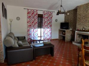 uma sala de estar com um sofá e uma lareira em Balcón al Valle em El Gastor