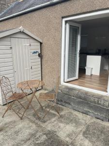 a table and two chairs sitting on a patio at SAM Lossiemouth Queens Lane in Lossiemouth