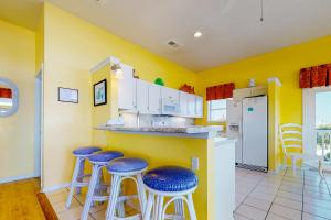 a kitchen with yellow walls and blue stools at Dream Chaser in St. George Island