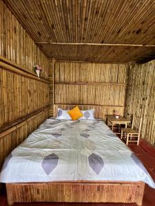 uma cama num quarto com tecto em madeira em Bamboo Villa em Gia Nghĩa