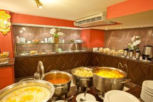 una cocina con varias ollas de comida en una barra en Dayrell Hotel e Centro De Convenções, en Belo Horizonte