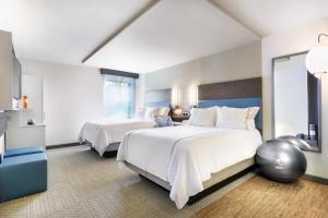 a bedroom with two beds and a large window at EVEN Hotel Norwalk, an IHG Hotel in Norwalk