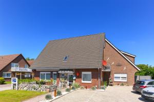 ein Haus mit einem davor geparkt in der Unterkunft Ferienwohnung Haus Boje "Knurrhahn" in Neuharlingersiel