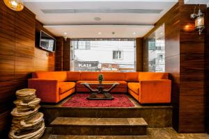 a living room with an orange couch and a table at Amritsar Grand By Levelup Hotels 100 meters from golden temple in Amritsar
