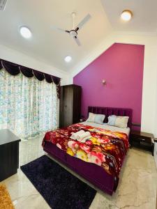 een slaapkamer met een groot bed met een paarse muur bij White Tulip in Lonavala
