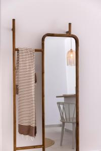 a mirror next to a table with a lamp at Kouros Village in Antiparos