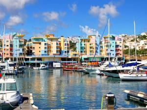 a group of boats docked in a marina with buildings at Marina Sea Residence in Albufeira