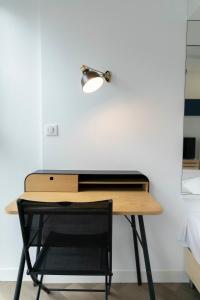 d'un bureau avec une chaise et une lampe sur un mur. dans l'établissement Studio moderne et confort au centre ville, à Metz