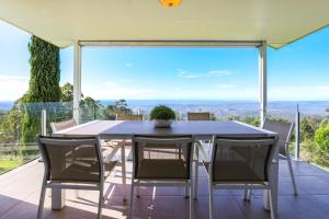 a dining table and chairs on the balcony of a house at Beautiful Home with Breath-taking Views Mt Tamborine in Eagle Heights