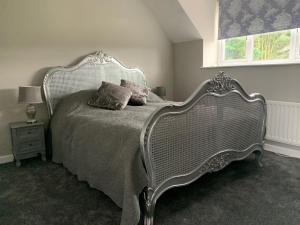 a bed with a metal frame in a bedroom at Stable Cottage in Ilminster