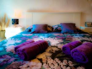 ein Schlafzimmer mit einem großen Bett und lila Kissen in der Unterkunft Pampas studio, self check-in, private parking in Poreč