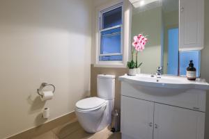 Eagle HeightsBeautiful Home with Breath-taking Views Mt Tamborine的带马桶和水槽的白色浴室 更多19张照片