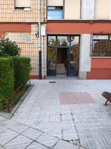an entrance to a building with a bench in front at Bonito piso Villafria in Oviedo