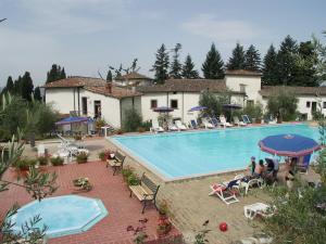 uma grande piscina com pessoas sentadas à sua volta em Villa Farmhouse with swimming pool in Chianti em Grassina