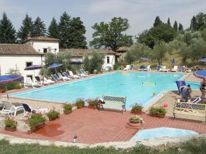 a large swimming pool with chairs and umbrellas at Villa Farmhouse with swimming pool in Chianti in Grassina +16 photos