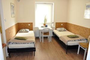 a room with two beds and a table and a desk at Apartamenty P7 Dzierżoniów in Dzierżoniów