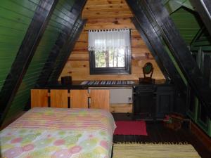 um quarto num chalé de madeira com uma cama e uma janela em Zeleni Čardaci etno apartmani em Kaludjerske Bare