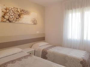 pokój z dwoma łóżkami i obrazem na ścianie w obiekcie Firstline apartment RUBINO Arenal-Bol Calpe w mieście Calpe